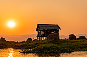 Hut on stilts on Inle Lake at sunset on boat trip, Nyaung Shwe, Myanmar