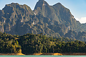 View of the Ratchaprapha lake with high karst rocks in the Khao Sok National Park, Khao Sok. Thailand