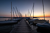 View of sailing boats on jetty on Lake Ammer at sunset, Bavaria, Germany, Europe