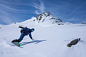 Snowboarder auf Splitboard im Tiefschnee bei der Abfahrt vom Tristkopf, Tirol im Winter, Österreich