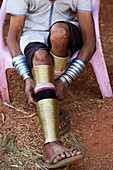 Kayan Lahwi Frau justiert die Messingringe, die sie um ihre Beine trägt.  Pan Pet Region, Bundesstaat Kayah, Myanmar.