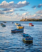 Boats floating in the harbor near Morro Castle , Havana, Cuba