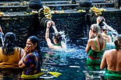 Ausländische Besucher baden am Wassertempel Tirta Empul, Bali, Indonesien