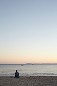 Mann betrachtet den Sonnenuntergang am Strand von Santa Barbara, Kalifornien, USA.