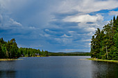 Dunkle Regenwolken über einem See, bei Sjöändan, Provinz Örebro, Schweden