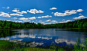 Wolken spiegeln sich in einem einsamen See im Naturreservat Bjuröklubb, Västerbottens Län, Schweden