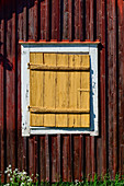 Gelber Fensterladen an einem historischen, roten Holzhaus, Lövanger Kyrkstad, Västerbottens Län, Schweden