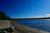 Meeresufer mit Strand bei blauem Himmel am Naturreservat Bjuröklubb, Västerbottens Län, Schweden