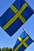 Zwei Schwedenflaggen vor blauem Himmel, Bjuröklubb, Västerbottens Län, Schweden