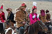Die Teilnehmer der Kyz Kuar-Spielshow (Ein Mädchen einholen), die sich für das traditionelle Reitspiel anstellten, waren die Jungen, die von den Mädchen ausgepeitscht wurden, wenn das Mädchen den Jungen fangen kann. beim Golden Eagle Festival (Adlerjägerfest) in der Nähe der Stadt Ulgii (Ölgii) in der Provinz Bajan-Ölgii in der Westmongolei