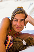 smiling woman resting with her young sleeping daughter, Cabo San Lucas, Mexico