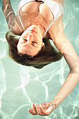 Caucasian woman floating in swimming pool