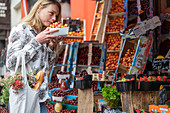 Junge Frau kauft Früchte am Marktstand
