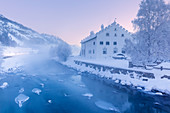 Frosty sunrise at Chesa Merleda with the frosen Inn river. La Punt, Engadine, Canton of Grisons, Switzerland, Europe.