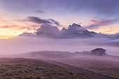 Der Nebel verbirgt eine Hütte und die Langkofelgruppe in der Morgendämmerung, Seiser Alm, Dolomiten, Provinz Bozen, Südtirol, Italien, Europa
