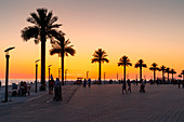 Sonnenuntergänge an der Strandpromenade des Kaspischen Meeres mit Menschen und Palmen, Aqtau, Region Mangghystau, Kasachstan, Eurasien