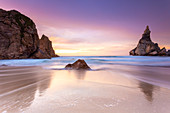 Sunset on the beach of Praia da Ursa with it's giant boulders. Cabo da Roca, Colares, Sintra, Portugal, Europe.