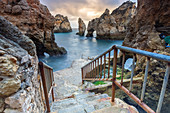 Treppe bei bewölktem Sonnenaufgang führt zum Ponta da Piedade, Lagos, Algarve, Portugal, Europa
