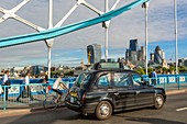 United Kingdom, London, the Thames, a London taxi on the Tower Bridge and the City