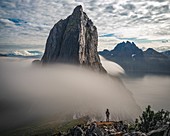 Wanderer am Fuss des Berges Segla Umgeben von Wolken, die in den Fjord Stürzen, Fjordgard, Senja, Norwegen