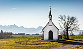 View of chapel in front of a mountain backdrop and blue sky, Söllhuben, Riedering, Bavaria, Germany
