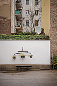 Ornamental tubs hang on wall in Berlin backyard, Berlin, Germany, Europe