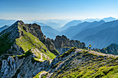 Woman hiking climbs up to Schöttelkarspitze, Schöttelkarspitze, Karwendel, Upper Bavaria, Bavaria, Germany