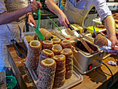 Trdelník is a kind of spit cake. It is made from rolled dough that is wrapped around a stick, then grilled and topped with sugar and walnut mix.\nTrdelník is found in several Central European countries, most prominently Austria, Czech Republic, Slovakia and Hungary (where it is known to come from the Hungarian-speaking part of Transylvania, Romania). The word "trdelník" is of Czech or Slovak origin.\nNowadays, trdelník is very popular among tourists as a sweet pastry in the Czech Republic. A modern version filled with ice cream or other fillings, has been spreading recently from Prague, the Czec