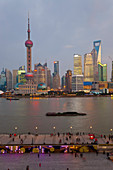 Lastkähne und die Skyline von Pudong in der Abenddämmerung, Shanghai, China
