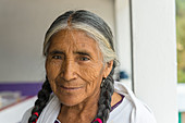 Porträt einer älteren mixtekischen Frau mit geflochtenem Haar im mixtekischen Dorf San Juan Contreras bei Oaxaca, Mexiko.