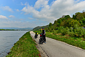 Radfahrer mit voll beladenen Rädern auf großer Tour am Donauradweg, bei Linz, Österreich