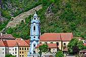 Die blaue Kirche von Stift Dürnstein vor den Berghängen an der Donau, Wachau, Österreich