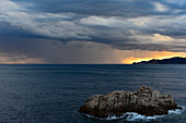 A rain front over the Mediterranean Sea approaches the rocky coast, Sant Feliu de Guixols, Catalonia, Spain