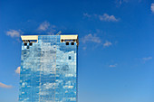 Hochhaus mit Glasfassade, in der sich der blaue Himmel und einige Wolken spiegeln, Barcelona, Katalonien, Spanien