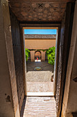 Patio des Generalife-Palastes (Palacio de Generalife) gesehen von einer alten Tür, Granada, Andalusien, Spanien