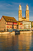 Straßenbahn in Limmatquai am Ufer des Flusses Limmat mit Großmünster-Kirche im Hintergrund, Zürich, Schweiz