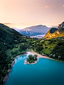 Sonnenaufgang im Tenno See mit Riva del Garda und Baldo Berg im Hintergrund. Tenno, Trentino Südtirol, Italien