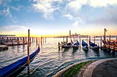 Gondolas near St Mark Square with San Giorgio Island on the background during sunrise. Venice, Veneto, Italy.