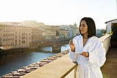 Frau mit einer Tasse Espresso auf Hotelbalkon, Florenz, Toskana, Italien