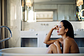 Frau entspannt sich in der Badewanne in einer Suite