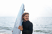 Surfer mit Surfbrett am Meer
