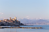 Frankreich, Alpes-Maritimes, Antibes, Point of the îlette, der alte Antibes und seine Wälle Vauban, beide sarazenische Türme der Burg Grimaldi mit im Hintergrund die schneebedeckten Alpen des Südens