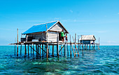Women and young boy in hut built over the water by Bajau fishermen, who live there for three months, Togian Islands, Indonesia, Southeast Asia, Asia