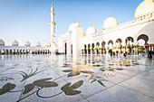 The domes and minarets of Abu Dhabi's Grand Mosque viewed across the large marble tiled central courtyard, Abu Dhabi, United Arab Emirates, Middle East