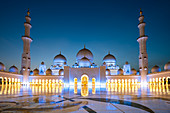 Abu Dhabis prächtige Große Moschee leuchtete während der abendlichen blauen Stunde in Abu Dhabi, Vereinigte Arabische Emirate, Naher Osten
