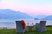 Sessel und Rotwein mit Blick auf den Comer See bei Sonnenuntergang, Lombardei, Italienische Seen, Italien, Europa