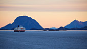 Encounter with the Hurtigruten ship Nordnorge at dawn, Rödöyfjord, Helgeland coasts, Nordland, Norway, Europe