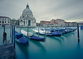 The 17th century church of Santa Maria della Salute across the Grand Canal with a row of gondolas slowly moving in the wind, Venice, UNESCO World Heritage Site, Veneto, Italy, Europe