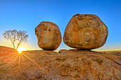 Sonnenuntergangslichtstrahlen bei Devils Marbles, den Eiern der mythischen Regenbogenschlange, im Karlu Karlu (Devils Marbles) Conservation Reserve. Outback, Rotes Zentrum, Northern Territory, Australien, Pazifik