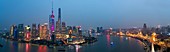 Skyline des Pudong-Finanzviertels über Huangpu-Fluss in der Dämmerung, Shanghai, China